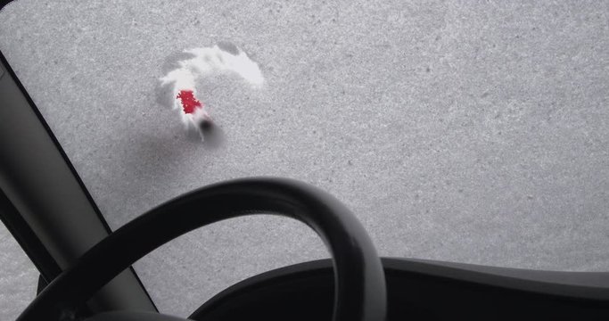 A woman is drawing a heart shape on the windscreen of a snow-covered car - ProRes