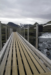 Obraz premium Wooden bridge over a mountain river in Iceland