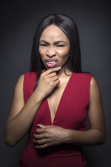 Black female model on a dark background with disgusted or irritated expressions.