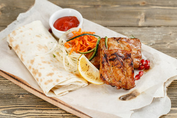 Grilled pork ribs. Serving on a wooden Board on a rustic table. Barbecue restaurant menu, a series of photos of different meats