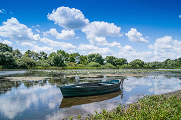 summer landscape: a river  reflect white curly clouds, on  river boat