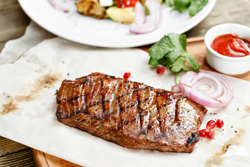 steak of marble beef, grilled. Serving on a wooden Board on a rustic table. Barbecue restaurant menu, a series of photos of different meats