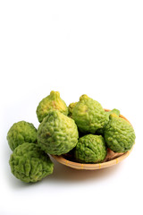 fresh bergamot fruit or the kaffir lime leaves in bamboo basket isolated on white background