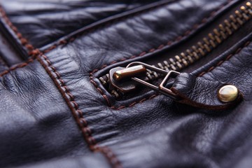 Brown leather texture with stitched seams and zipper, details of leather jacket, close up