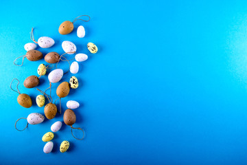 Small easter eggs different size on blue background with copy space. Top view.
