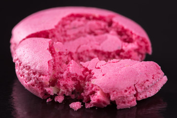 Macaroons of soft pink color on a black background.