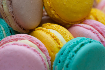 Colorful pastel macaroons background, top view. French almond cookies. Toned image.