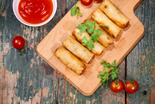 Vietnamese food. Delicious homemade spring rolls on wooden table.