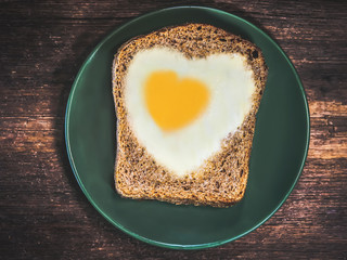bread with fried eggs in the shape of a heart symbol