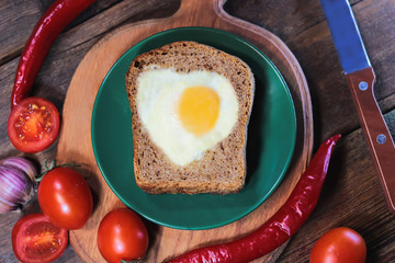 bread with fried eggs in the shape of a heart symbol