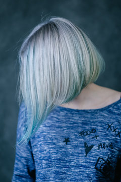 Portrait of beautiful russian woman with colouring blue, green and grey blonde hair in photo studio in salon of hairstyle