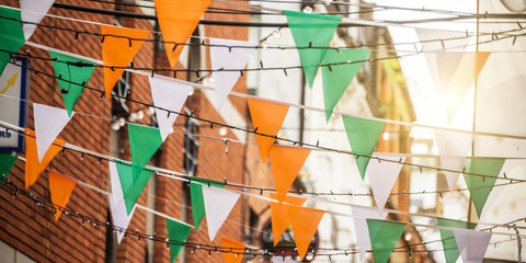 Fototapeta Garland with irish flag colors in a street of Dublin, Ireland - Patriotic banners, Saint Patrick day celebration concept obraz
