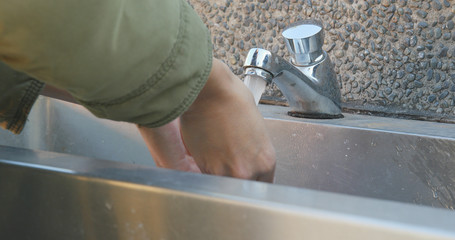 Washing hands in a public toilet