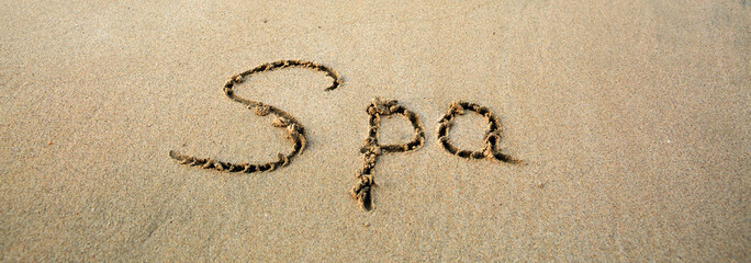 Word Spa written on the sand near the sea.Vacation concept.