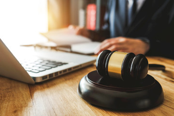 justice and law concept.Male judge in a courtroom  the gavel,working with digital tablet computer...