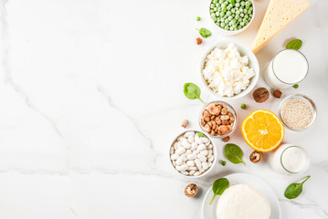 Fototapeta na wymiar Healthy food concept. Set of food rich in calcium - dairy and vegan Ca products, white marble background top view copy space
