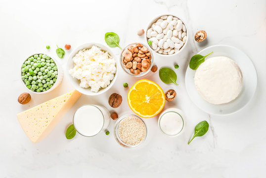Healthy food concept. Set of food rich in calcium - dairy and vegan Ca products, white marble background top view copy space