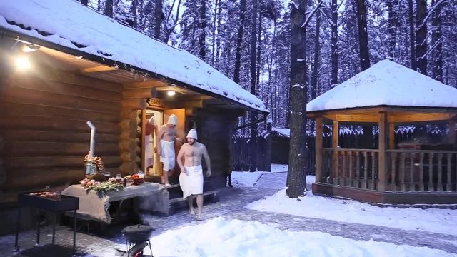 Men relax in Russian bath. men go without clothes from the bath at outdoor