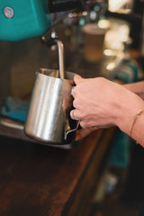 Fototapeta na wymiar barista making coffee, steaming the milk