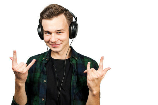 White young guy listen to music in the ear-phones and whows sign that rocks, isolated