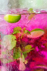 Pink tea karkade with mint and lime. Macro in the street in the decanter.