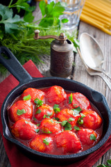 Meatballs in tomato sauce in a cast-iron frying pan, selective focus
