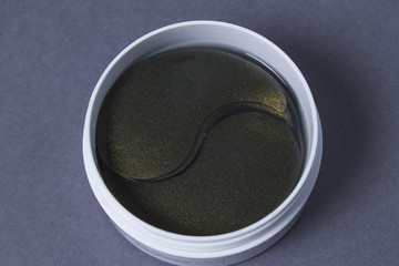 Black gold eye patches close up on grey background