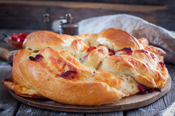 Cooked round cake made from yeast dough with dried tomatoes and cheese, horizontal