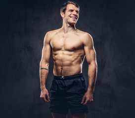 Fototapeta na wymiar Studio portrait of a shirtless athletic tattooed male