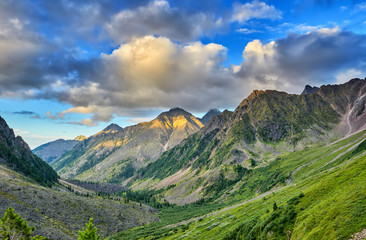 Evening sky with cumulus clouds over mountain valley