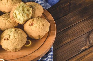 Lemon cupcakes on a wooden Board on the table with a blue towel.