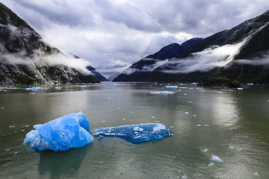 Spectacular Tracy Arm Fjord, brilliant blue icebergs and backlit clearing mist, mountains and South Sawyer Glacier, Alaska