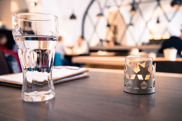 Teelicht mit Sternen in Cafe, Menschen im Hintergrund