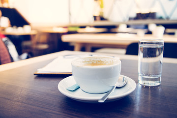 Kaffeetasse mit Wasserglas auf Holztisch. Konzept.