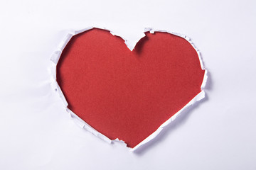 Naklejka na ściany i meble Heart shape hole through paper 