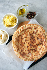 Mashed potato and sheep cheese filling flatbread on a white stone background.