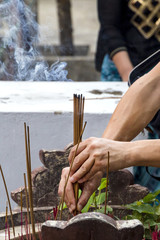 a man puts burning incense sticks in a special bowl (Vietnam,Nha Trang City, Long Son pagoda 2018-01-10 )