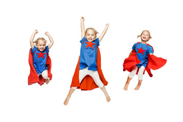 Very excited little girl dressed like hero jumping isolated on white background.