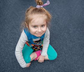 Cute girl sitting on the floor in the gym