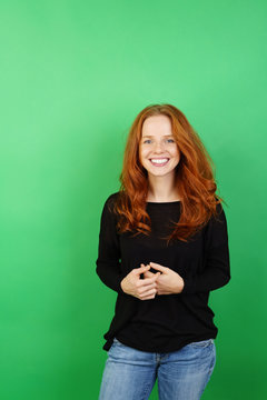 Cheerful woman standing against green background