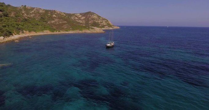 Aerial, a lonely sailing ship in a beautiful bay with crystalline water