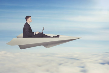 businessman with paper plane and laptop