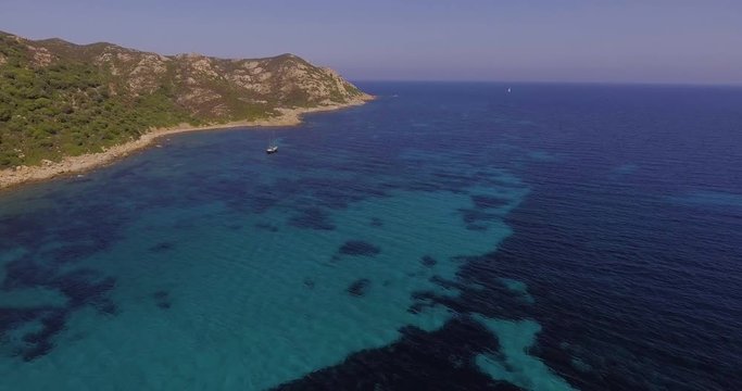 Aerial, a lonely sailing ship in a beautiful bay with crystalline water