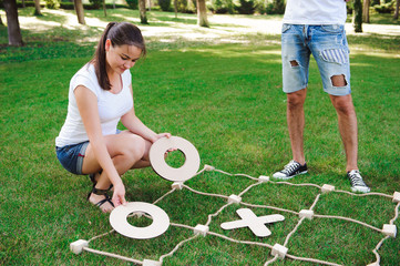Big Tic Tac Toe game. Guy and girl playing outdoors.