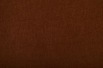Fragment of the surface of fibrous synthetic non-woven material of brown color. Background, texture - obrazy, fototapety, plakaty