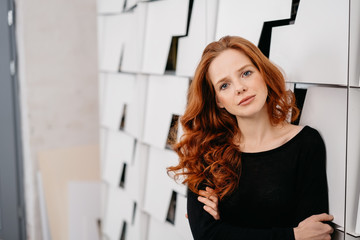 Pretty serious redhead woman looking at camera