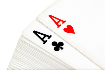 Full deck of playing cards with aces of clubs and hearts on top, isolated on white background