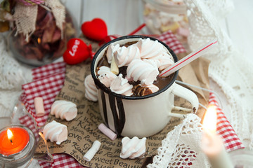 Mug of hot chocolate drink with marshmallow candies on top and candles on white background. Valentin's day love concept.