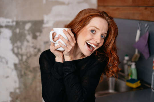 Smiling young woman holding cup of coffee