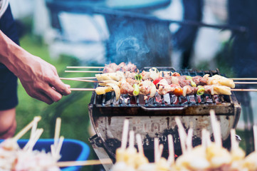 Man grill barbecue on hot charcoal grill place - outdoor garden party concept